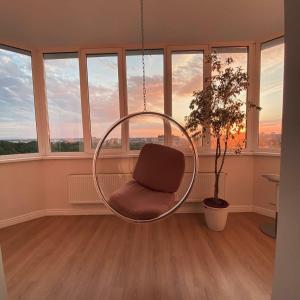 un fauteuil suspendu dans une pièce avec fenêtres dans l'établissement Premium apartament & Penthouse - Center, à Krasnodar