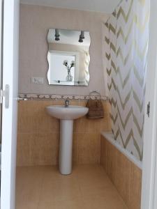 een badkamer met een wastafel en een spiegel bij Casa Marlu in Alozaina