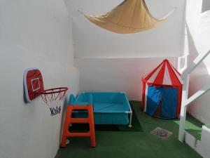 een speelkamer met een basketbalring en een basketbalring bij Casa Marlu in Alozaina