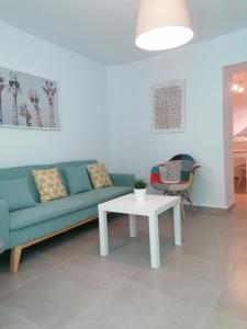 - un salon avec un canapé bleu et une table dans l'établissement Casa Marlu, à Alozaina