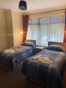 Habitación de hotel con 2 camas y ventana en The Burlington Hotel, en Torquay