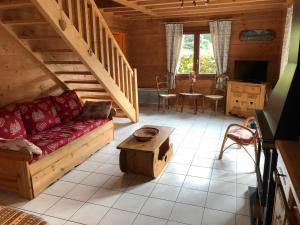 ein Wohnzimmer mit einem Sofa und einem Tisch in der Unterkunft CHALET 10 COUCHAGES EN HAUTE SAVOIE in La Chapelle-dʼAbondance
