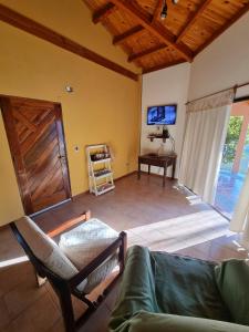 un salon avec un canapé et une télévision dans l'établissement Calisto casa, por los caminos del vino, Mendoza, à Luján de Cuyo