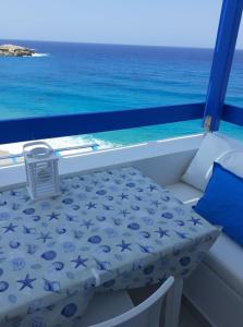 un tavolo e una sedia su un balcone con vista sull'oceano di Blue and White Studios & Apartments a Lefkos Karpathou