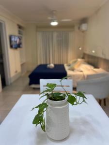 una planta en un jarrón blanco sentado en una mesa en Apart Sur Departamento en Santa Fe