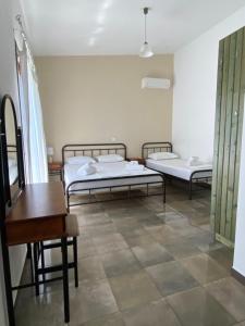 two beds in a room with a tiled floor at Kryoneri village in Kryonéri