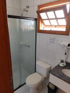 La salle de bains est pourvue de toilettes, d'une douche et d'un lavabo. dans l'établissement Pousada Tempo Rei, à Boicucanga