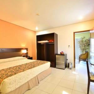 um quarto de hotel com uma cama grande e uma cadeira em SBS Hotel & Spa em Assunção