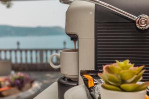 a coffee maker pouring coffee into a cup on a counter at Apartments Belvedere in Herceg-Novi