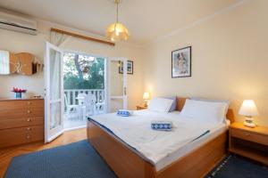 a bedroom with a large bed and a balcony at Villa Ban in Podgora
