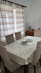 a dining room table with a white table cloth on it at Lovcen Holiday Home in Cetinje