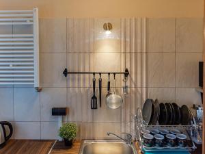 eine Küche mit einem Waschbecken und Küchenutensilien an der Wand in der Unterkunft VacationClub – 300 Mill Pokój 3 in Szklarska Poręba
