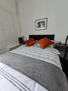 ein Schlafzimmer mit einem großen Bett mit orangefarbenen Kissen in der Unterkunft No.8 in Stornoway