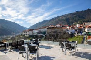 uma varanda com mesas e cadeiras com vista para uma cidade em Hotel da Vila em Manteigas