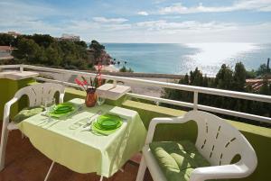 d'une table et de chaises sur un balcon avec vue sur l'océan. dans l'établissement Apartamentos Casa Blanca, à Miami Platja