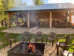 Whitetail Creek Camping Resort في Lead: مجموعة من الكراسي حول حفرة النار في الفناء +17 صورة