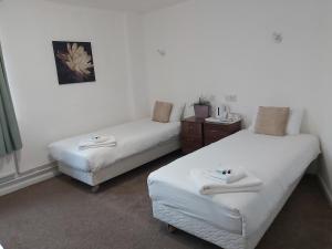 two beds in a room with white walls at Midlands Hotel in Mansfield