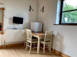 a room with a table and two chairs and a television at Brecks Cottage in Newark-on-Trent