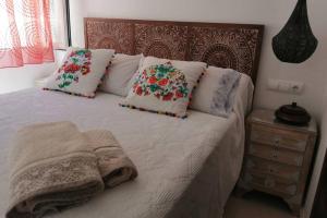 1 dormitorio con cama con almohadas y cabecero de madera en ÁTICO EXCLUSIVO EN EL CENTRO DE GRANADA, en Granada
