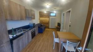 a kitchen and a living room with a table and chairs at Appartamenti il Bersaio Alloggio 1 in Sambuco