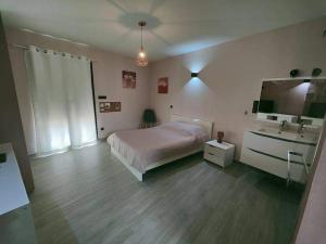 um quarto grande com uma cama e um lavatório em La Détente em Malaucène