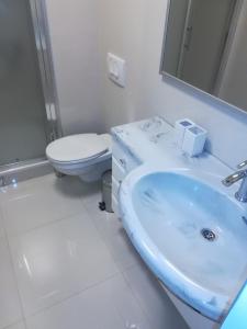 a white bathroom with a sink and a toilet at Apartments Bohemia - Center in Zlatibor
