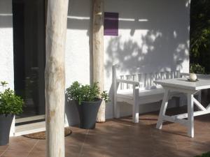 a porch with a white table and a bench at Residenza Nialiccia in Abbiadori