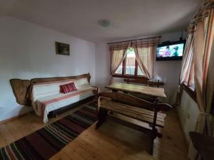 a room with two beds and a table and windows at Вила 111 in Sapareva Banya