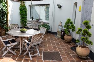 a patio with a table and chairs and potted plants at Bed 'n Blues **** in Halen