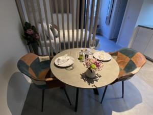a table with chairs and a vase of flowers on it at Apartments Hidden paradise Rovinj in Rovinj