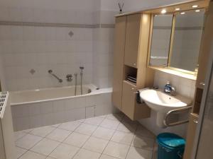 ein Badezimmer mit einem Waschbecken, einer Badewanne und einem WC in der Unterkunft Ferienwohnung auf einem Gutshof in Nordenham