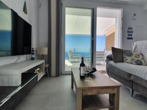salon z kanapą i stołem z butelkami wina w obiekcie Bayview Hills - Balcón del Mediterráneo w mieście Torrox