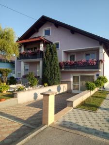 une maison avec 2 balcons et des fleurs sur elle dans l'établissement Apartman Karmen Gospić, à Gospić