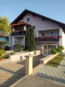 a house with two balconies and flowers on it at Apartman Karmen Gospić in Gospić