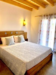 sypialnia z dużym łóżkiem z drewnianym zagłówkiem w obiekcie Quinta das Aguas w Aljezur