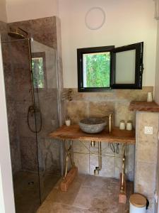 uma casa de banho com um chuveiro, um lavatório e um espelho. em Domaine de La Michelle em Madaillan