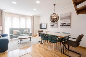 a living room with a table and chairs and a couch at DE LA GUARDIA SUITE ROSAL in Oviedo