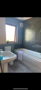 uma casa de banho com uma banheira, um WC e um lavatório. em No 52 - Apartment with Lounge and Dining Area - No kitchen em Ullapool