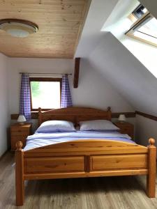 - une chambre mansardée avec un lit en bois dans l'établissement Chalupa Brtníky, à Staré Křečany