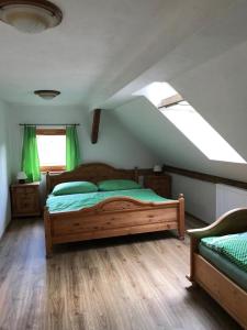 1 dormitorio con cama de madera con sábanas verdes en Chalupa Brtníky, en Staré Křečany