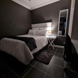 a bedroom with a bed and a table with a mirror at Vusi's Guesthouse in Durban