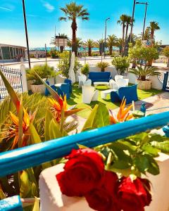 a patio with tables and chairs and a red rose at Hotel Ambassador in Grottammare