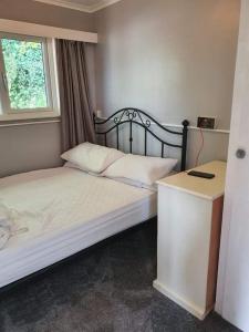 1 dormitorio con cama, ventana y escritorio en Springside Chalet20 en Tywyn