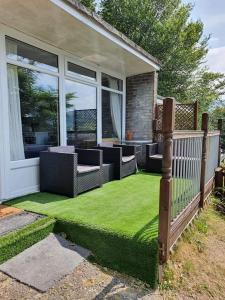 un patio con césped verde en la parte delantera de una casa en Springside Chalet20 en Tywyn