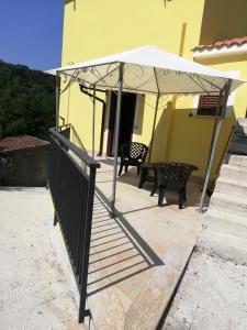 patio z białym parasolem i ławką w obiekcie Masseria da Federica w mieście Tufo