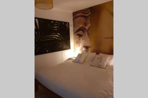 a bed with two pillows and a statue of a head at LOVE ROOM OUT OF TIME *JACUZZI* in Itteville
