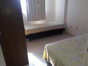 1 dormitorio pequeño con 2 camas en una habitación en Edificio Castel Gandolfo, en Guarapari