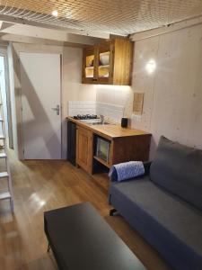 a living room with a couch and a kitchen at Tiny House Cosy 2 - Angers Green Lodge in Angers