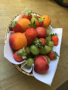 een fruitmand met aardbeien en sinaasappelen op een tafel bij Chambre d'hôtes de charme MERBLEUESOLEIL in Six-Fours-les-Plages