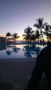 uitzicht op een zwembad met palmbomen bij zonsondergang bij private apartment estudio ocean view solo adultos in La Laguna